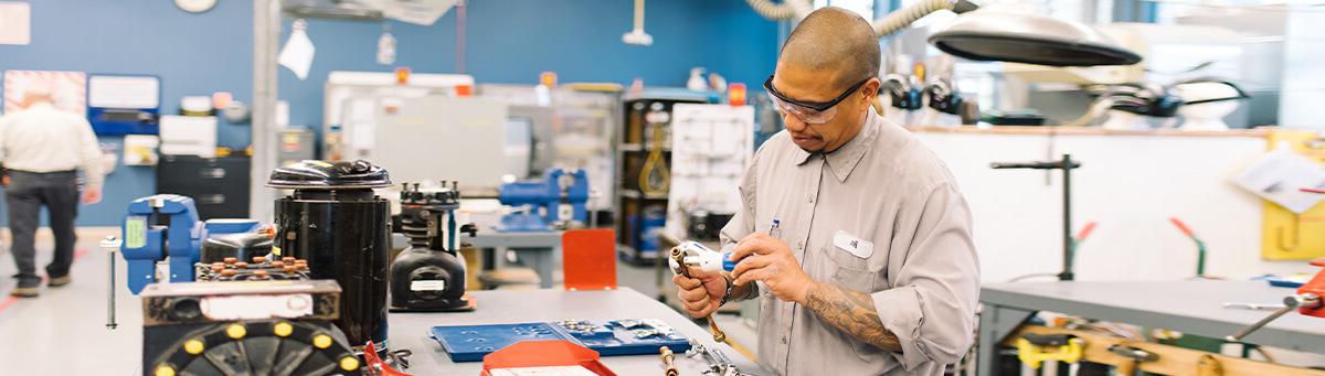 A student works on manufacturing equipment in a Pima Lab